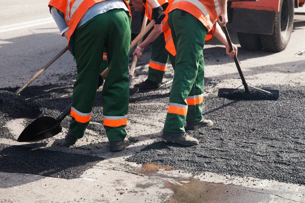 Road Street tamirat sırasında kaldırım makinesinde çalışan işçiler. Sokak yeniden ortaya çıkıyor. Taze asfalt yapısı. Kötü yol.. — Stok fotoğraf