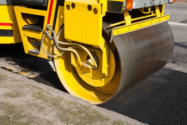 Pavement machine laying fresh asphalt or bitumen on top of the gravel base during highway construction. — Stock Photo, Image