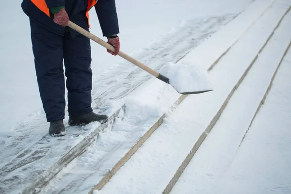 Os trabalhadores varrem a neve da estrada no inverno, limpando a estrada da tempestade de neve . — Fotografia de Stock