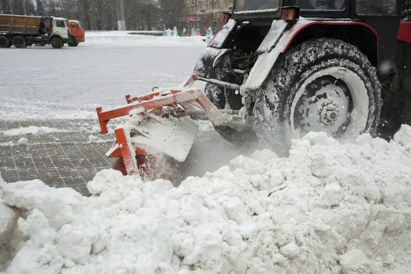 Trator limpa a neve com uma escova na avenida da cidade. — Fotografia de Stock