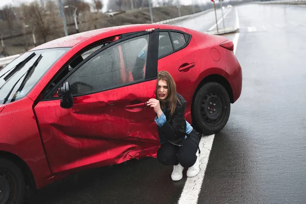 Kobieta siedzi w pobliżu zepsutego samochodu po wypadku. Wezwij pomoc. ubezpieczenie samochodu. — Zdjęcie stockowe