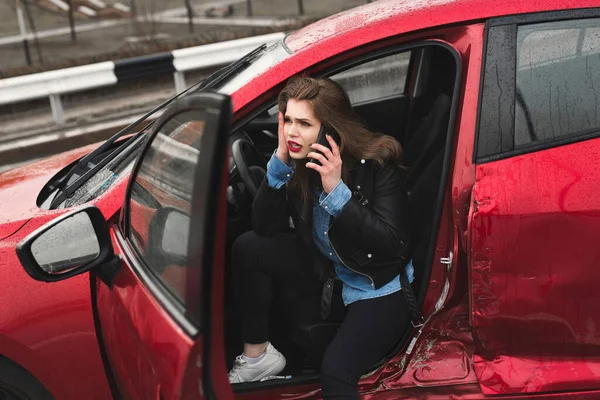 Joven mujer bastante asustada en el coche. Mujer llama a un servicio de rescate . — Foto de Stock