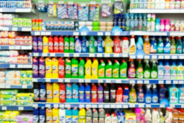 Bir süpermarkette birçok farklı marka çamaşır suyu ve toz ile görüntüle. Bulanık.