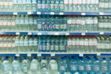 Süpermarketin arka planında raflardaki su şişeleri ürünü
