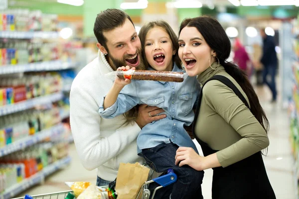 Familia con carrito de compras con comida visitando supermercado . — Foto de Stock