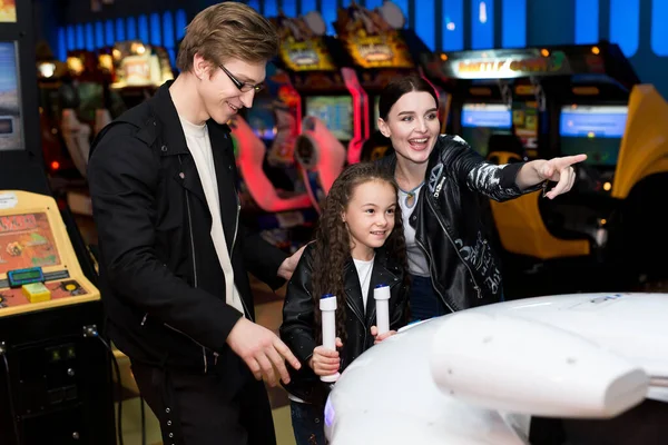 Aile annesi, babası ve kızı lunaparktaki bilgisayar makinelerinde oyun oynuyorlar. Çocuklar ve yetişkinler kumar makinelerinde oynarlar, alışveriş merkezinde eğlenirler.