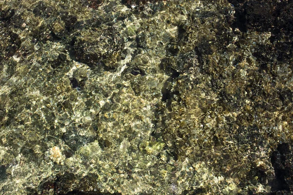 浅水水和光从卵石中散落在晶莹清澈的水中。使一个优秀的电脑屏幕背景. — 图库照片