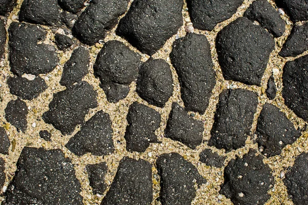 Piedra negra húmeda y arena como telón de fondo . — Foto de Stock