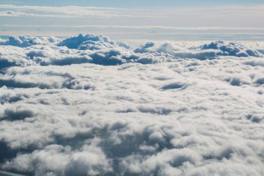 Uçak penceresinden bulutların görüntüsü.