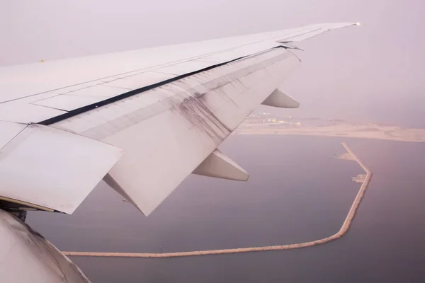 O avião descola sobre a cidade. Vista da asa da aeronave . — Fotografia de Stock