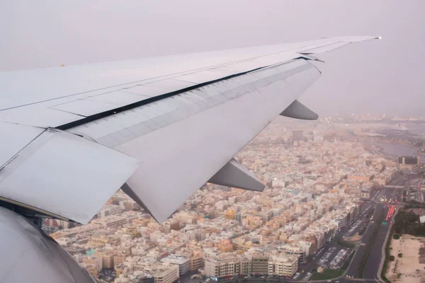 飞机在城市上空起飞.飞机机翼的视图. — 图库照片