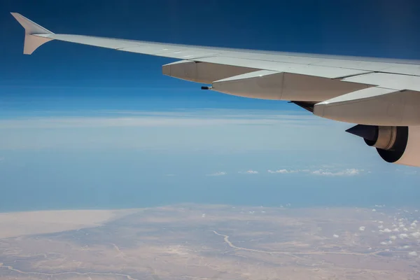 Planet lyfter över staden. Utsikt över flygplansvingen. — Stockfoto