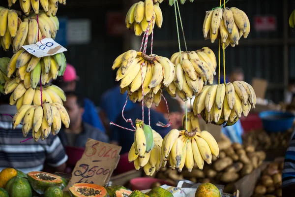 The market in bananas and people are buying fruit at the farmers market in Mauritius.