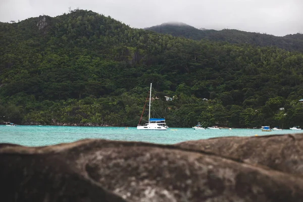 Iate e água azul do oceano Maurício no fundo de uma montanha . — Fotografia de Stock