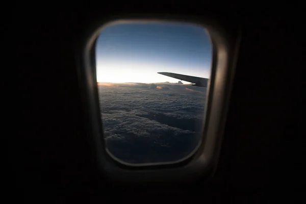 从云层上的平面窗口看日出. — 图库照片