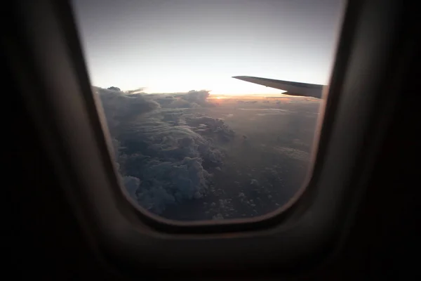 Vue du lever du soleil depuis la fenêtre de l'avion sur les nuages . — Photo