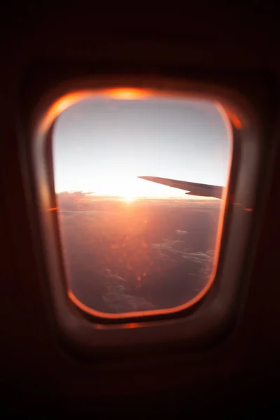 从云层上的平面窗口看日出. — 图库照片