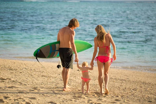 Jaki sport lubisz najbardziej? family dad, mom and daughter walking on the beach. — Zdjęcie stockowe