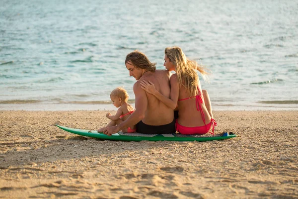 Серфінг. щаслива родина сидить на дошці для серфінгу. концепція про сім'ю, спорт і розваги . — стокове фото