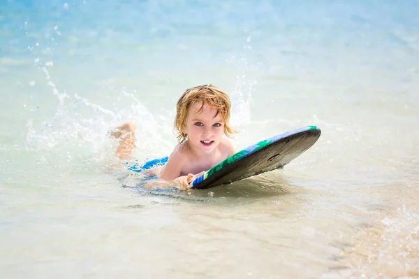 Junger Surfer, glücklicher kleiner Junge im Meer auf dem Surfbrett. — Stockfoto