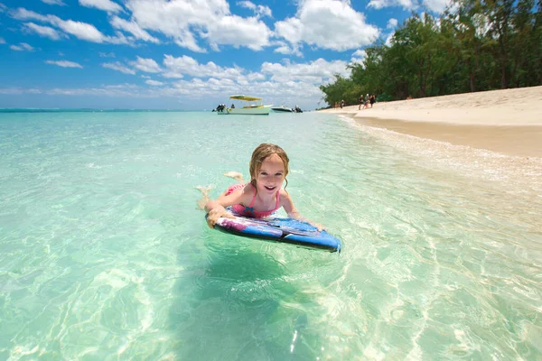 Pequena menina - jovem surfista com bodyboard tem uma diversão em pequenas ondas do oceano. Estilo de vida familiar ativo . — Fotografia de Stock