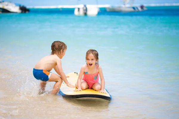 Zwillinge Bruder und Schwester haben Spaß beim Surfen im Meer. — Stockfoto