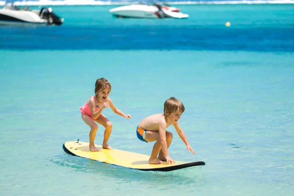 Zwillinge Bruder und Schwester haben Spaß beim Surfen im Meer. — Stockfoto