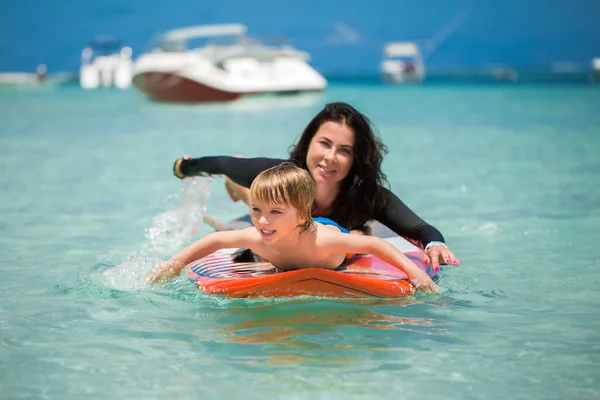 Mutter und Sohn surfen auf der Tafel im Meer. — Stockfoto