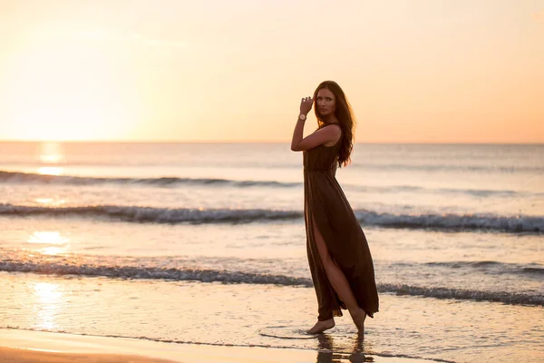 Hermosa mujer en el fondo del atardecer. Colorido amanecer sobre el mar. Mujer despreocupada disfrutando de la puesta de sol en la playa. Estilo de vida feliz . —  Fotos de Stock