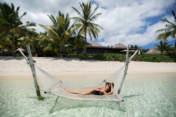 Mulher em rede na praia tropical na ilha . — Fotografia de Stock