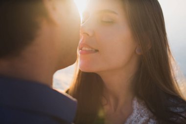 Gelin ve damat şefkatle öpüşürler. Seksi öpüşme stili aşıklar portreyi yakından çekiyorlar..