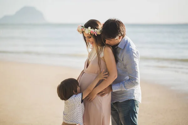 Zwangere vrouw, baby en gemengde ras man op het strand. — Stockfoto