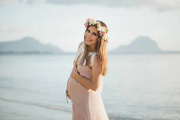 Έγκυος γυναίκα σε ένα όμορφο φόρεμα στον ωκεανό. — Φωτογραφία Αρχείου