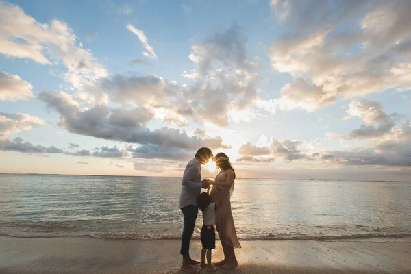 Pregnant mother father and son on the beach, delighted the sunset. — Stock Photo, Image