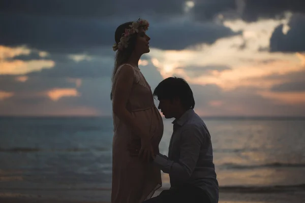 Hermosa chica embarazada y hombre al atardecer . — Foto de Stock