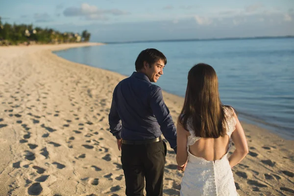 Brud och brudgum promenader på stranden i Mauritius. — Stockfoto