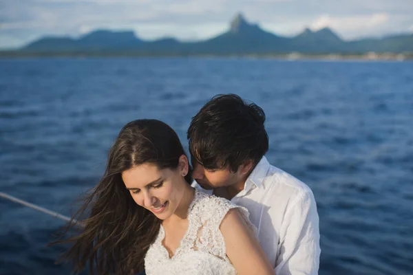 Casal bonito noiva e noivo no iate no dia do casamento ao ar livre no mar. Casal feliz beijando no barco no oceano. Casamento marinho elegante . — Fotografia de Stock