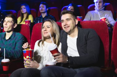 Mutlu genç çift sinemada oturuyor ve film izlemekten zevk alıyor..
