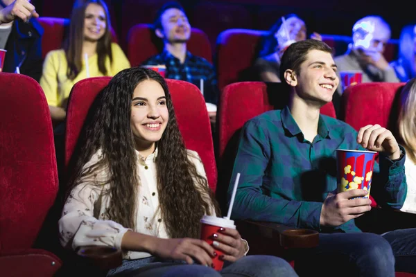 Amigos sentam-se e comem pipocas juntos enquanto assistem filmes em um cinema . — Fotografia de Stock