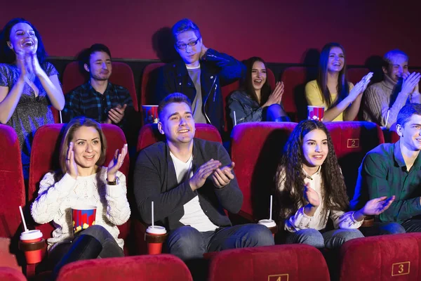 Счастливая улыбающаяся публика хлопает в ладоши, сидя в кинотеатре и смотря кино . — стоковое фото