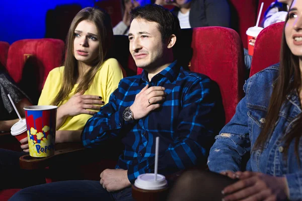 Amigos um homem e uma mulher estão assistindo um filme em um cinema chorando — Fotografia de Stock