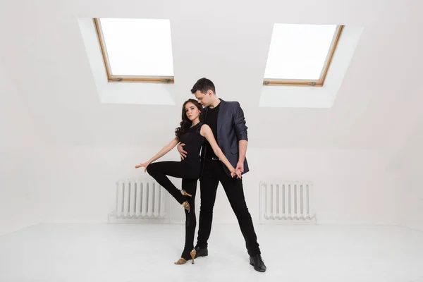 Lindo casal dança bachata no fundo branco no estúdio . — Fotografia de Stock