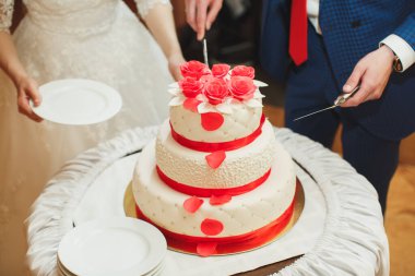 Düğün pastası. Gelin ve damat ziyafette pastayı kestiler.