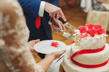 Düğün pastası. Gelin ve damat ziyafette pastayı kestiler.
