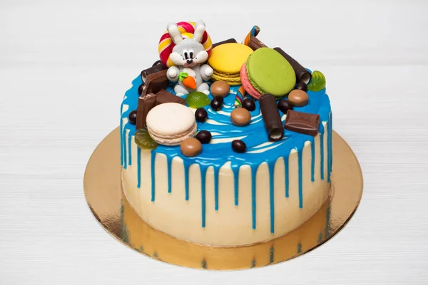 Modrý dort s postavou zajíce, makarónů a čokolády. — Stock fotografie
