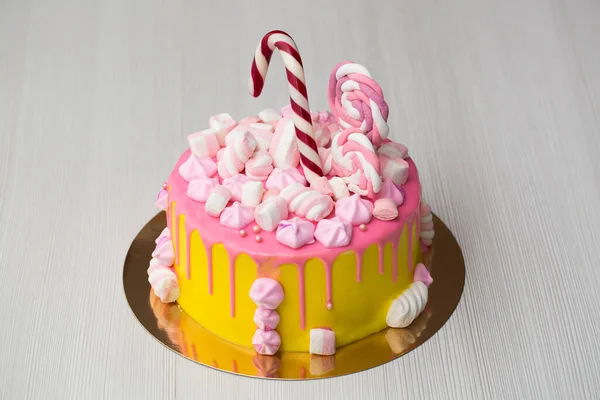 孩子们的黄色蛋糕，上面有粉红色的糖霜、糖霜和糖果. — 图库照片