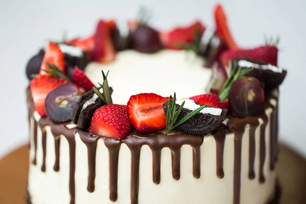 有巧克力渍、草莓、葡萄、迷迭香的蛋糕. — 图库照片