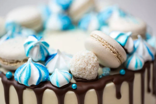 Торт с шоколадными полосками, голубой меренгой и макаронами . — стоковое фото