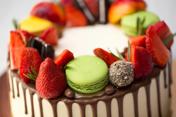 Pastel con gotas de chocolate, fresas, melocotones, macarrones, romero . —  Fotos de Stock