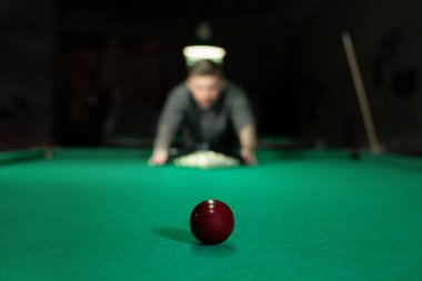 Bilardo oyunu. Adam topları yeşil bilardo masasına koyuyor.
